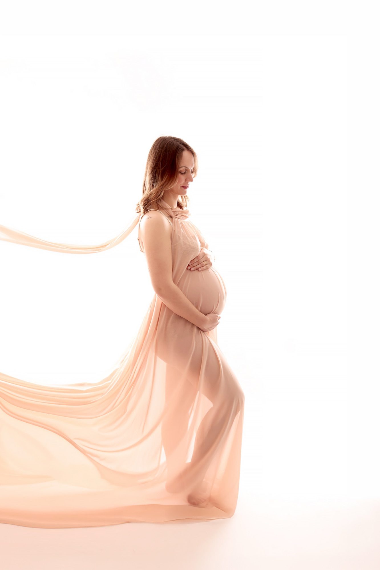 Future maman lors d'une séance grossesse en studio, lumière douce